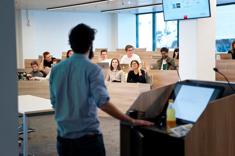 The back of a CEU faculty member standing at a podium in a large classroom.