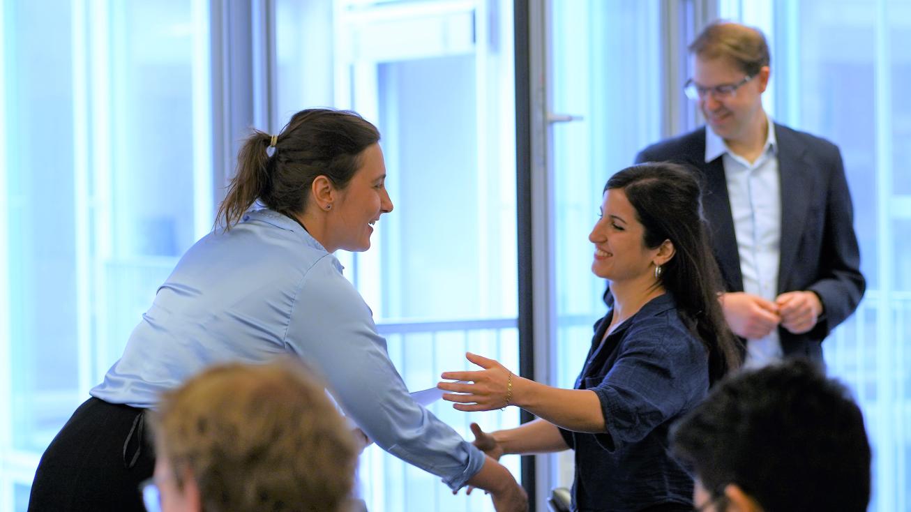 Yehuda Elkana Center faculty shaking hands with a certificate recipient. 
